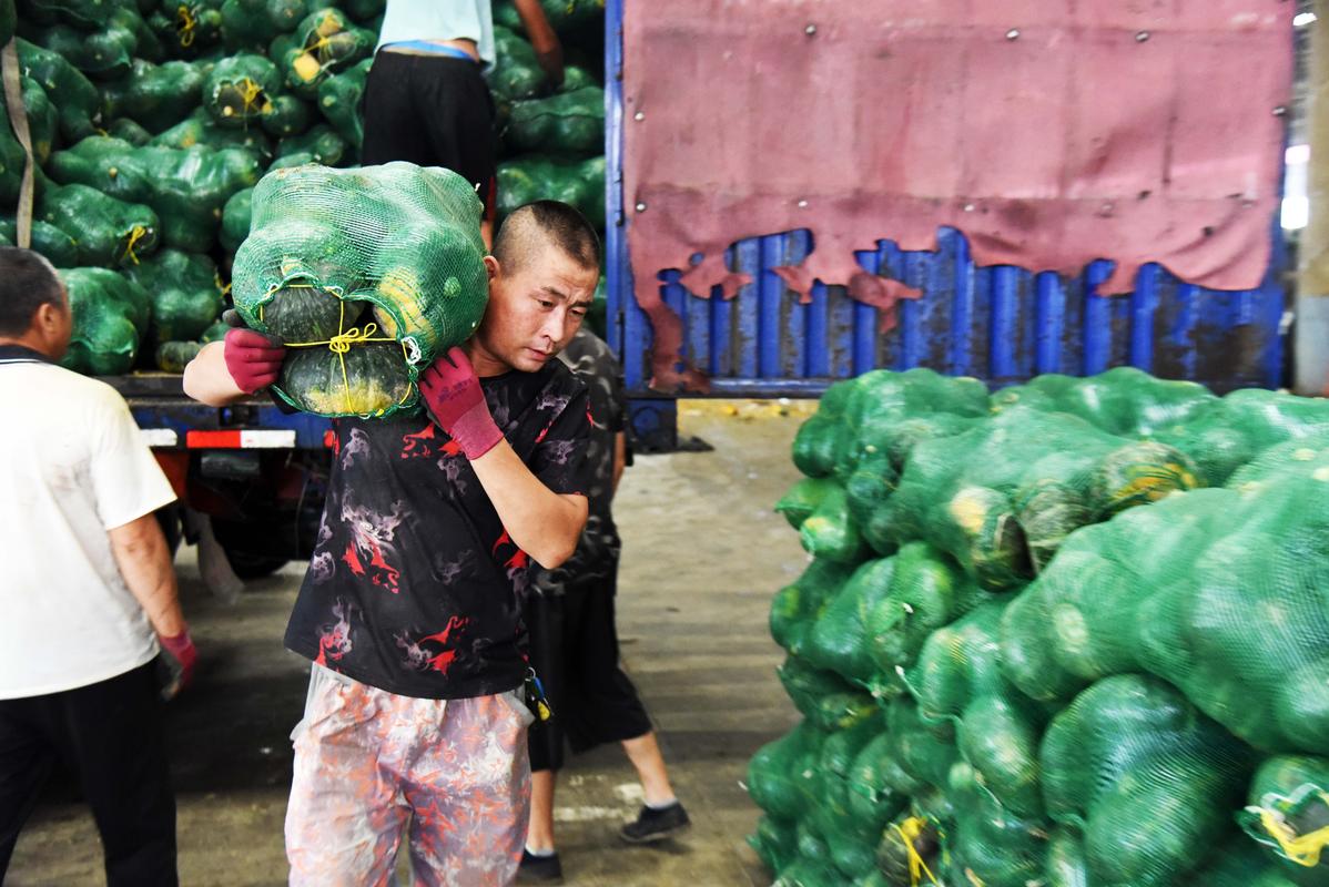 8月13日,在寿光农产品物流园,工作人员在搬运农产品.